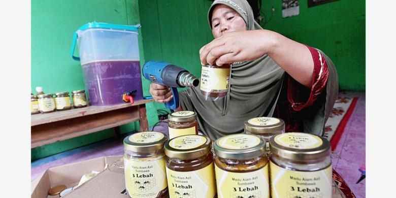 Jueria (39), pedagang madu di Desa Batudulang, Kecamatan Batulanteh, Kabupaten Sumbawa, Nusa Tenggara Barat, memberi label pada botol kemasan madu. Madu tersebut, antara lain, dijual ke Mataram dan Bali.