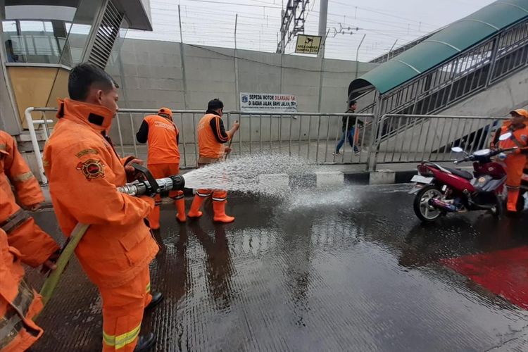 Sejumlah petugas Damkar dan Petugas Dishub DKI sirami jalan di Stasiun MRT Lebak Bulus, Jakarta Selatan karena warga keluhkan bau pesing, Kamis (15/8/2019)