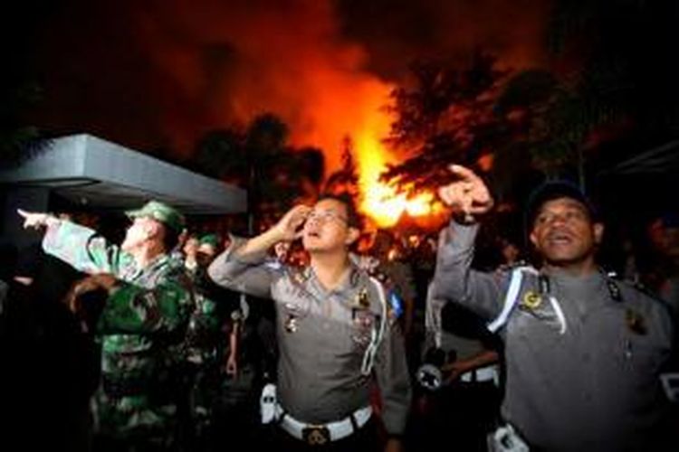 Polisi dan tentara melakukan penjagaan di saat petugas pemadam kebakaran memadamkan api yang melumat bangunan Lembaga Pemasyarakatan (Lapas) Klas I Tanjung Gusta, Medan, Kamis (11/7/2013) malam. Lapas diduga dibakar narapidana akibat adanya pemadaman listrik dan matinya air PDAM dalam Lapas.