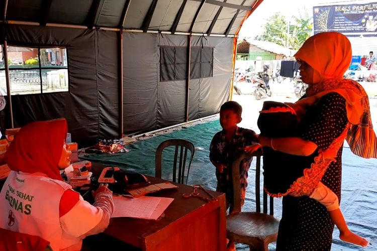 Pengungsi nampak memeriksakan diri di posko kesehatan Desa Wonoketingal, Kecamatan Karanganyar, Kabupaten Demak, Senin (19/2/2024). (KOMPAS.COM/NUR ZAIDI)