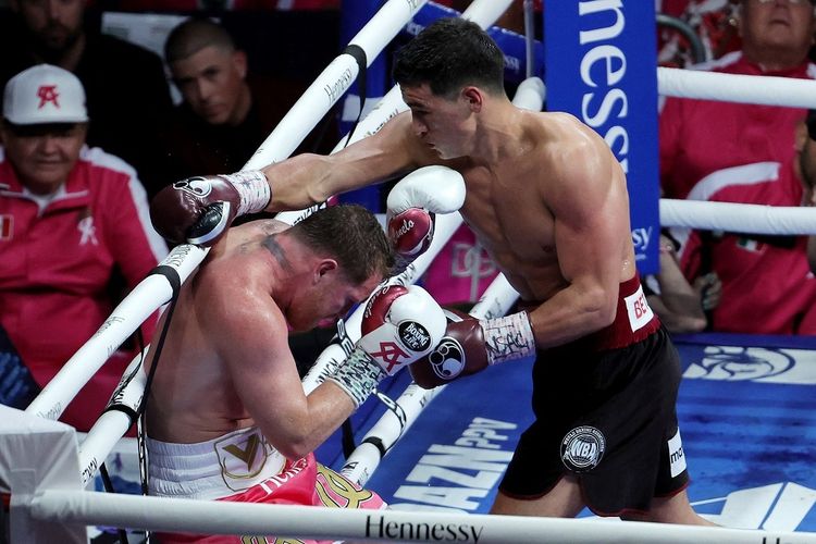 Dmitry Bivol (kanan) bertukar pukulan dengan Canelo Alvarez dalam perebutan gelar kelas berat ringan WBA di T-Mobile Arena, Las Vegas, Nevada, Amerika Serikat, pada Minggu (8/5/2022) pagi WIB.