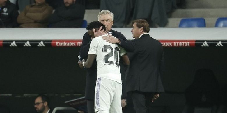 Vinicius Junior berselebrasi bersama Carlo Ancelotti usai mencetak gol buat Real Madrid dalam laga kontra Valencia di Liga Spanyol. Laga Real Madrid vs Valencia digelar di Stadion Santiago Bernabeu pada 2 Februari 2023. Terkini, Ancelotti akan memimpin skuad Real Madrid pada laga leg kedua babak 16 besar Liga Champions 2022-2023 kontra Liverpool. (Foto dari BURAK AKBULUT / ANADOLU AGENCY / Anadolu Agency via AFP)