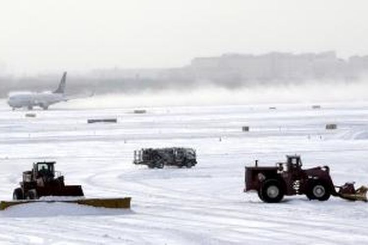 Sebuah pesawat lepas landas dari Bandara Internasional Newark, New Jersey, Jumat (3/12/2013) di tengah dampak badai salju.