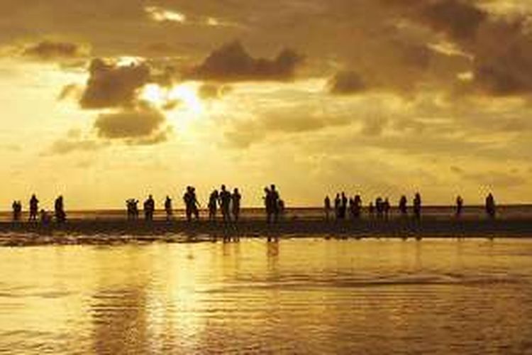 Pengunjung menikmati pijar cahaya keemasan matahari senja di Pantai Kaluku, Desa Limboro, Kecamatan Banawa Tengah, Kabupaten Donggala, Sulawesi Tengah, seperti terlihat pada Minggu (10/7/2016). Pantai tersebut mulai diserbu penikmat wisata bahari dalam enam bulan terakhir. 