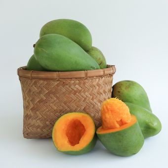 Ilustrasi buah mangga alpukat di matangkan di dalam keranjang
