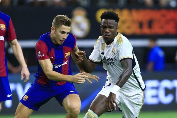 Duel Vinicius Junior (kanan) dengan Fermin Lopez (kiri) dalam laga Soccer Champions Tour antara Barcelona vs Real Madrid di AT & T Stadium, Arlington, Texas, Amerika Serikat, 29 Juli 2023. (Photo by Aric Becker / AFP)