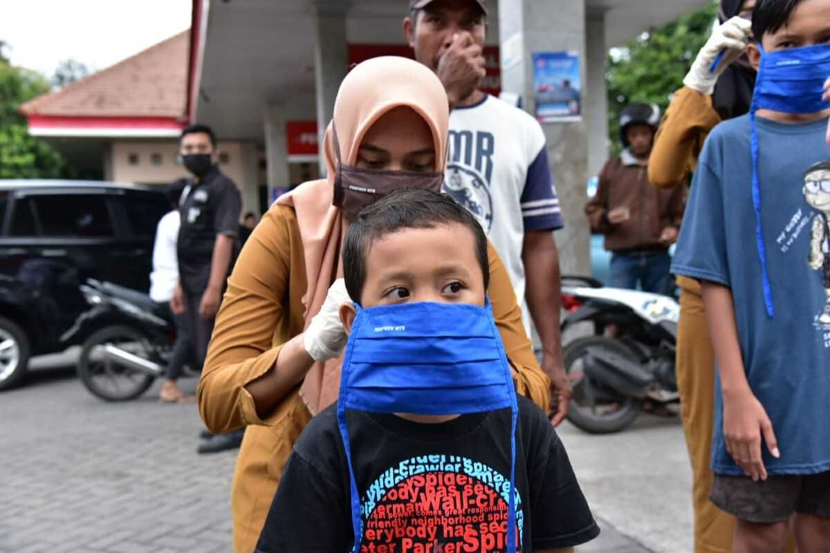 Petugas membagikan masker kain buatan UMKM.