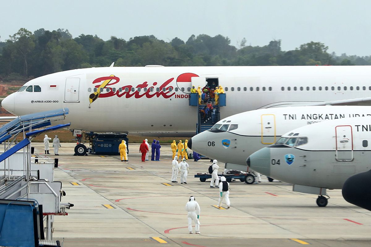 Sebanyak 250 WNI yang dievakuasi dari Kota Wuhan, China turun dari pesawat setibanya di Bandara Hang Nadim, Batam, Kepulauan Riau, Minggu (2/2/2020). WNI yang dievakuasi dari Wuhan tersebut kemudian diterbangkan kembali menuju Ranai, Natuna untuk menjalani observasi.