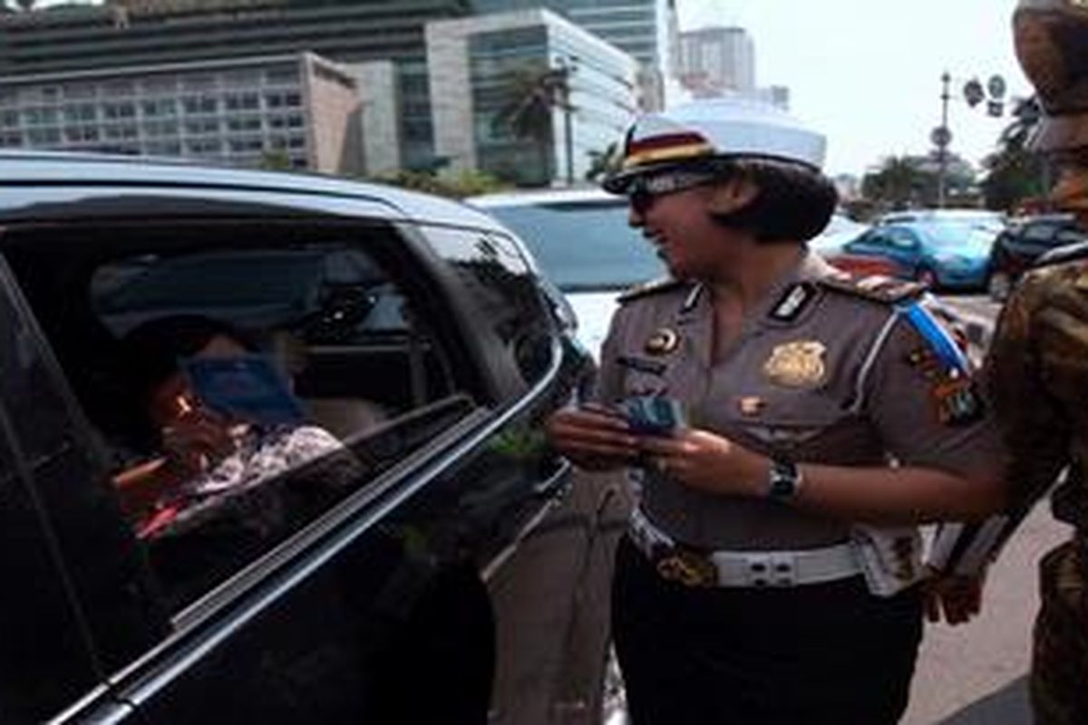 Polisi Lalu Lintas membagikan selebaran tips aman berkendara kepada pengguna jalan di Kawasan Bundaran Hotel Indonesia, Jakarta Pusat, Senin (6/5/2013). Selain untuk kampanye aman berkendara, aksi itu juga untuk sosialisasi Operasi Simpatik Kepolisian yang akan berlangsung selama 21 hari kedepan.
