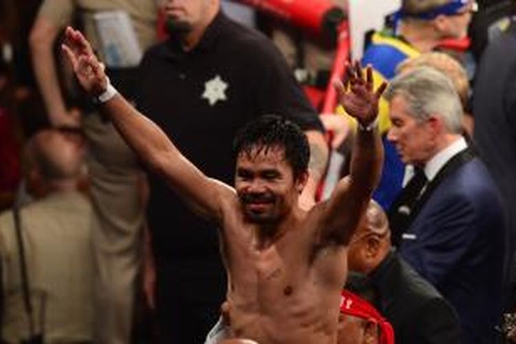 Manny Pacquiao mengangkat kedua tangan usai pertarungan dengan Floyd Mayweather Jr. di MGM Grand Garden Arena, Las Vegas, Nevada, Sabtu (2/5/2015) malam atau Minggu pagi WIB.