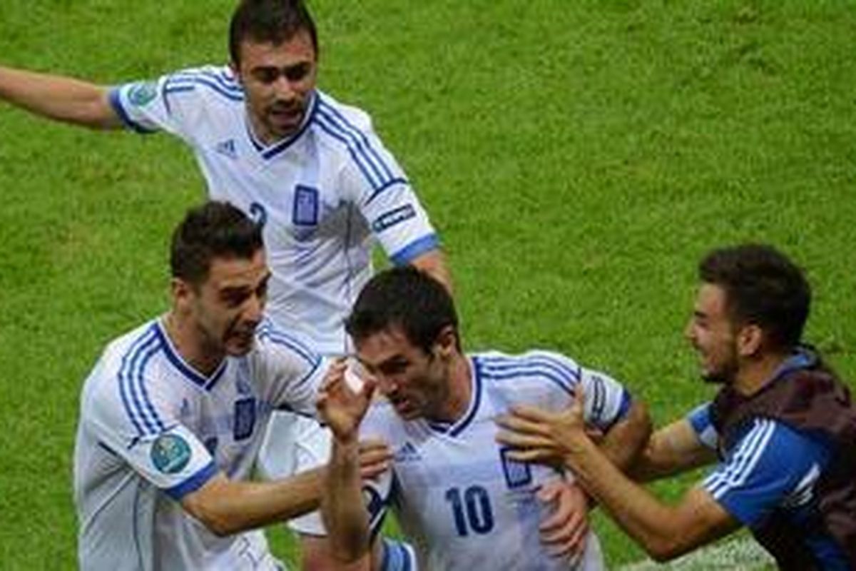 Gelandang Yunani, Giorgos Karagounis (tengah), merayakan golnya ke gawang Rusia, pada pertandingan ketiga Grup A Piala Eropa, di Stadion Nasional Warsawa, Sabtu (16/6/2012).