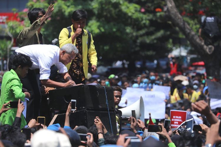 Gubernur Jawa Tengah Ganjar Pranowo saat menandatangani tuntutan aksi demo di depan massa mahasiswa di kantor Gubernuran Jawa Tengah, Selasa (24/9/2019).
