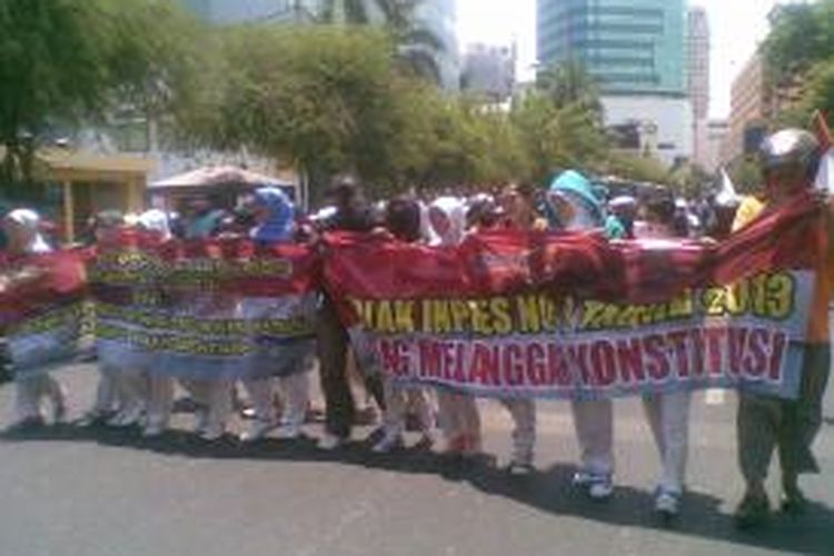Massa buruh menggelar aksi unjuk rasa di depan Gedung Grahadi, Surabaya, Kamis (17/10/2013).