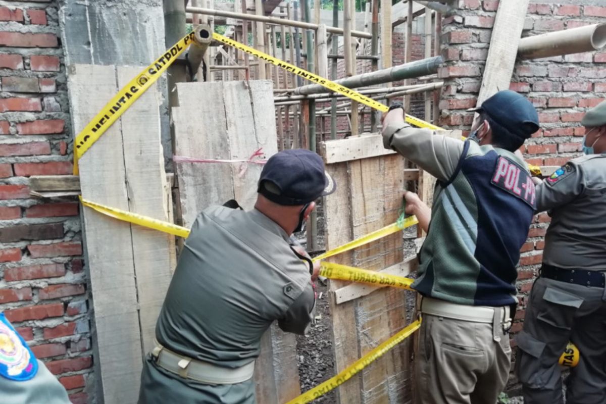 Petugas Satpol PP Kabupaten Garut memasang Garis Satpol PP saat menghrntikan pembangunan masjid Jamaah Ahmadiyah di Kampung Nyalindung Desa Ngamplang Kecamatan Cilawu, Kamis (6/5/2021) siang (Dok Jamaah Ahmadiyah Indonesia)