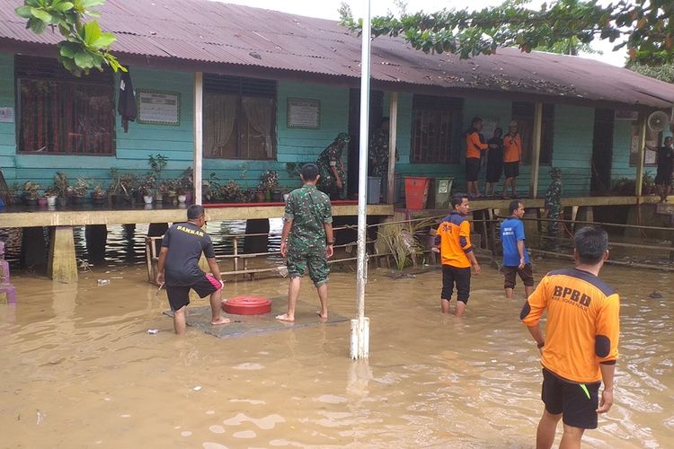 Prajurit TNI bersama BPBD, kepolisian, PLN dan Damkar membersihkan sekolah madrasah usai dilanda banjir di Kota Pasir Pengaraian, Kabupaten Rohul, Riau, Rabu (27/11/2019).