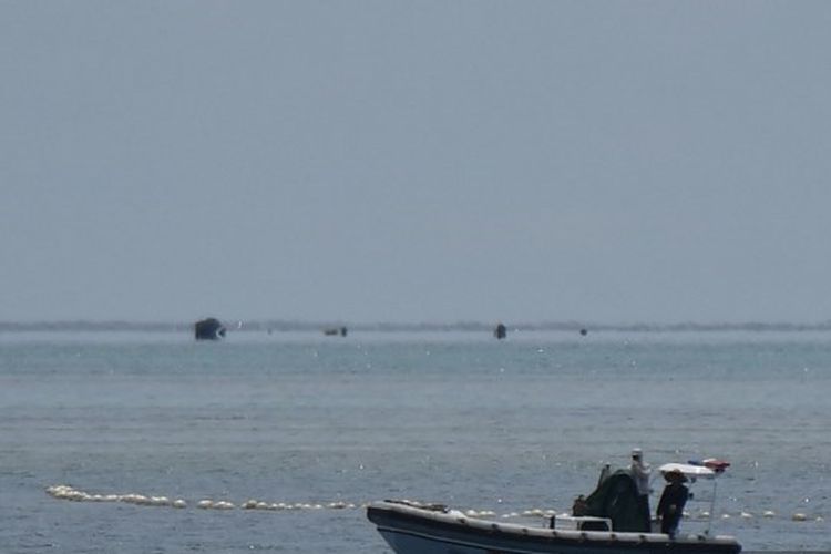 Foto yang diambil pada 22 September 2023 ini menunjukkan personel pasukan penjaga pantai China berada di atas perahu karet lambung kaku mereka di samping penghalang terapung saat mereka menjaga jalur menuju Scarborough Shoal yang dikuasai China di perairan Laut China Selatan yang disengketakan. Tiongkok, yang mengklaim kedaulatan atas hampir seluruh Laut Cina Selatan, merebut kendali atas Scarborough Shoal dari Filipina pada tahun 2012. Sejak saat itu, China telah mengerahkan kapal penjaga pantai dan kapal-kapal lain untuk memblokir atau membatasi akses ke daerah penangkapan ikan yang telah dimanfaatkan oleh beberapa generasi warga Filipina. 