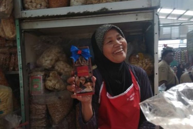 Bu Slamet, pedagang keripik gadung di Pasar Kranggan Yogyakarta menunjukan suvenir yang diberikan oleh Presiden Jokowi.
