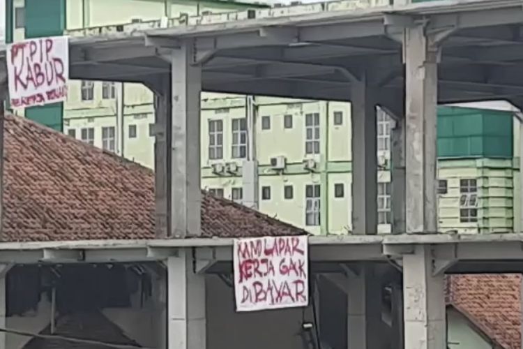Puluhan pekerja proyek poliklinik RSUD Soekardjo Tasikmalaya protes pemborong kabur dan upah kerjanya belum dibayar dengan memasang spanduk protes di lokasi proyek mangkrak, Jumat (11/2/2022).
