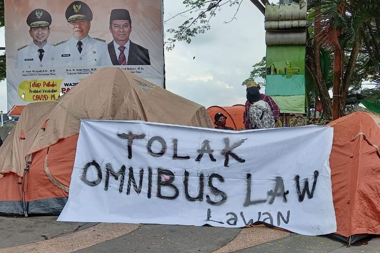 Spanduk penolakan omnibus law UU Cipta Kerja dibentang pada dua tenda berkemah di depan Kantor Gubernur Kaltim, Jalan Gajah Mada, Samarinda, Sabtu (10/10/2020). 