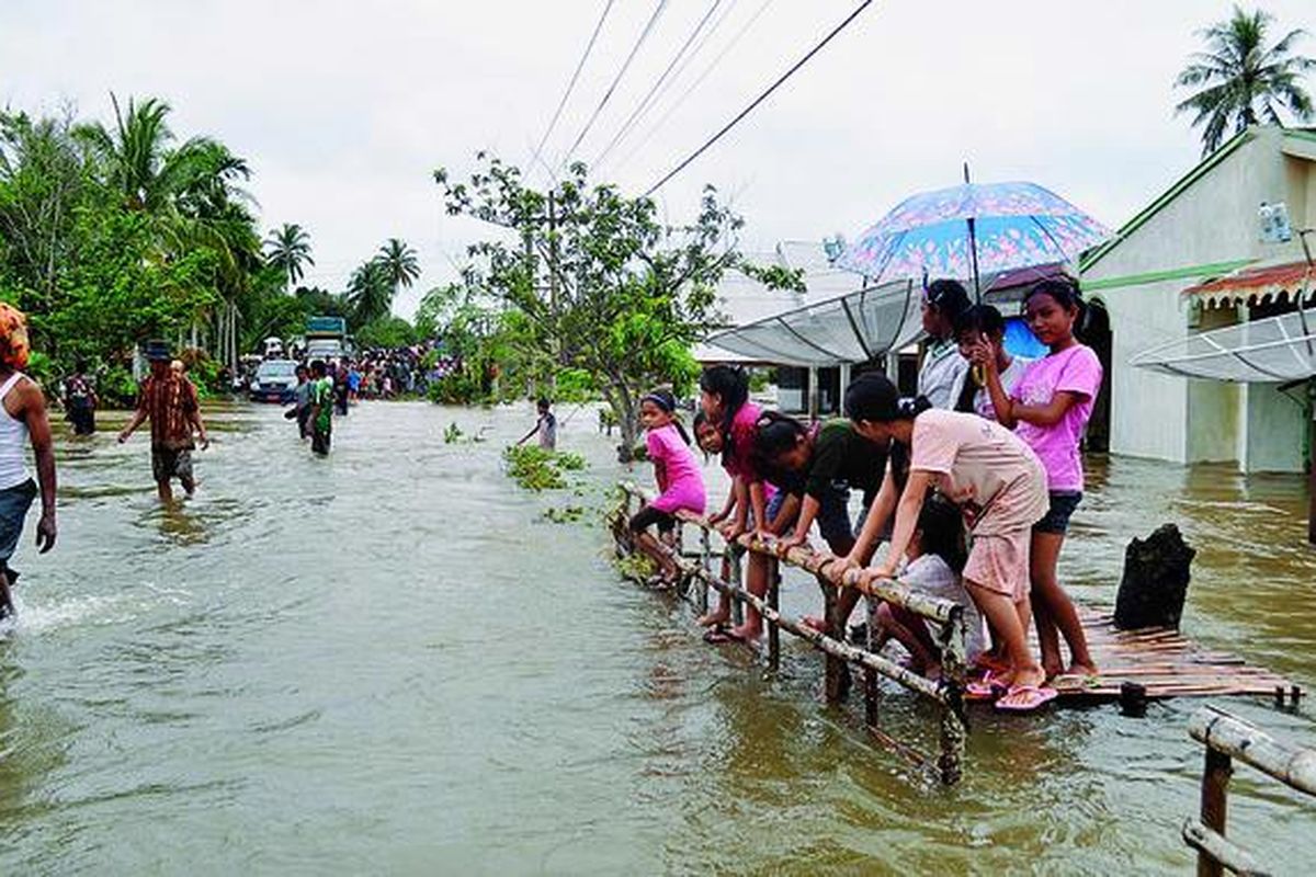 Sejumlah bocah di Nagari Sungai Sirah, Kecamatan Sutera, Kabupaten Pesisir Selatan, Sumatera Barat, Kamis (3/11), berdiri di depan rumah-rumah warga yang dilanda banjir. Selain banjir, terjangan air bah dan longsor juga melanda sejumlah wilayah di Kabupaten Pesisir Selatan sejak Kamis dini hari.