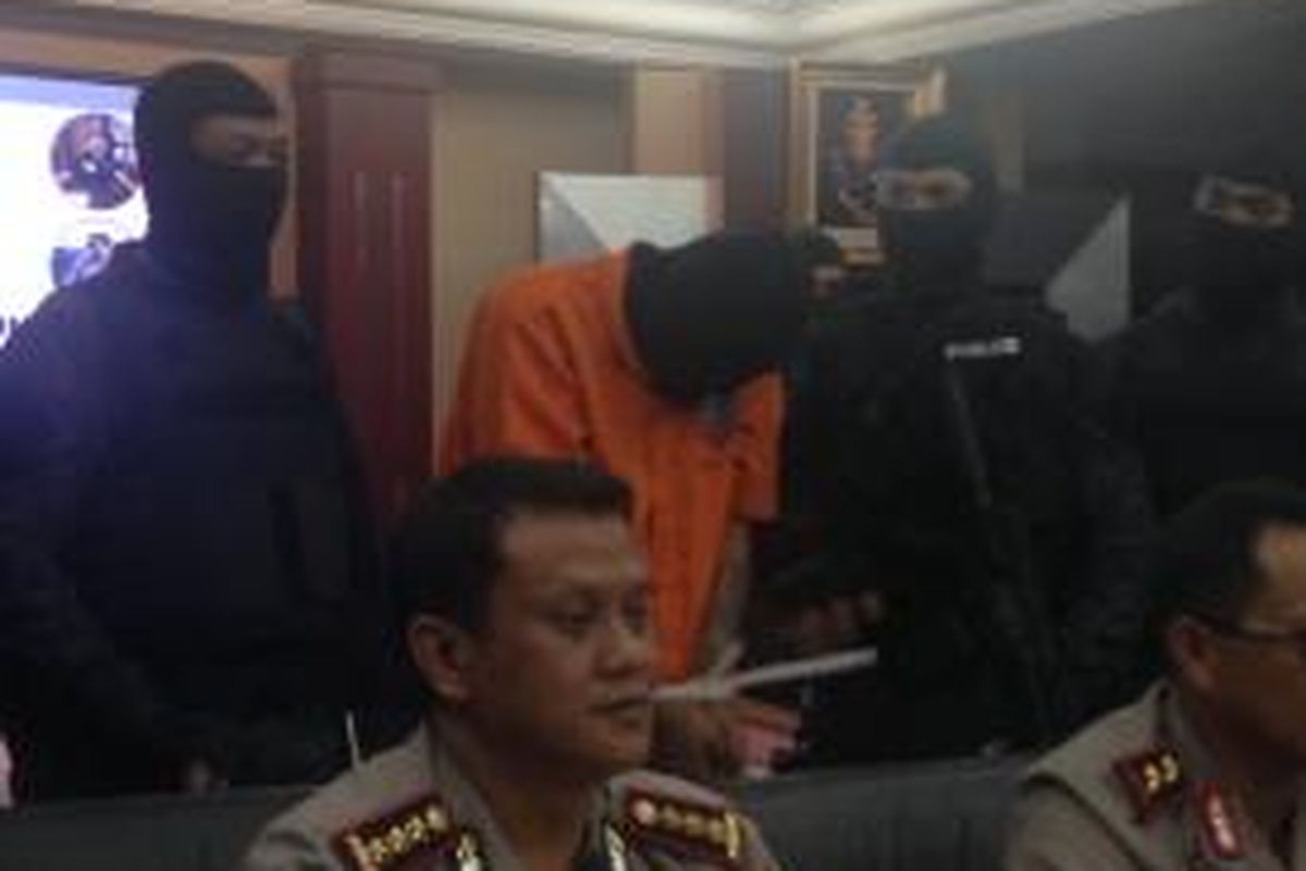 A (39), tersangka pembunuh bocah dalam kardus di Kalideres, Jakarta Barat, PNF (9), menunduk sepanjang rilis pengungkapan kasus tersebut di Mapolda Metro Jaya, Sabtu (10/10/2015).