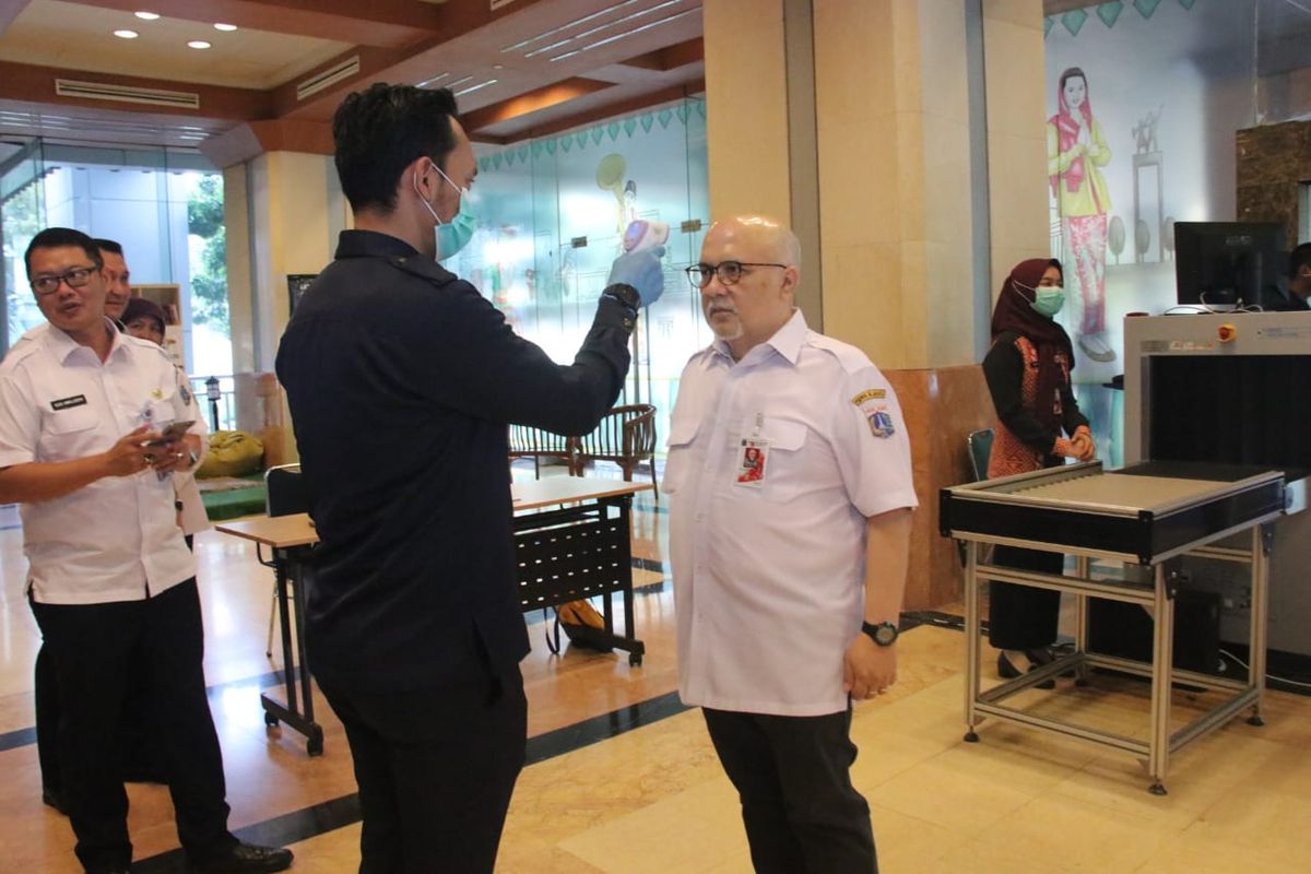 Asisten Pemerintahan Sekda DKI Jakarta Artal Reswan Soewardjo saat diperiksa suhu tubuhnya di Balai Kota dalam rangka antisipasi Virus Corona, Rabu (4/3/2020)