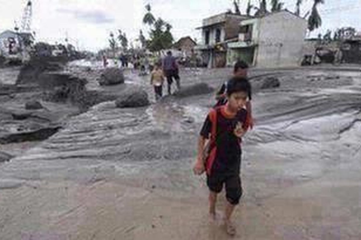Endapan material Gunung Merapi yang terbawa banjir lahar dingin di Jalan Yogyakarta-Magelang, Desa Jumoyo, Salam, Magelang, Jawa Tengah, Jumat (4/2/2011). Selain mengakibatkan jalur utama Yogyakarta-Magelang terputus, banjir lahar dingin juga mengakibatkan sejumlah tiang beton yang baru saja dipasang untuk memperkuat pondasi jalan menjadi miring.