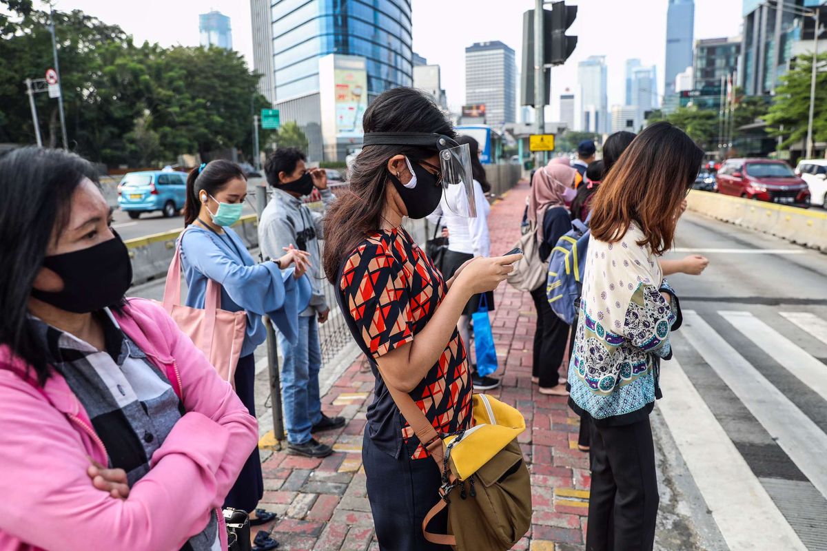 Pekerja yang menggunakan masker saat menunggu menyebrangi zebra cross di Jalan M.H Thamrin, Jakarta Pusat, Senin (14/9/2020). PSBB kembali diterapkan tanggal 14 September 2020, berbagai aktivitas kembali dibatasi yakni aktivitas perkantoran, usaha, transportasi, hingga fasilitas umum.