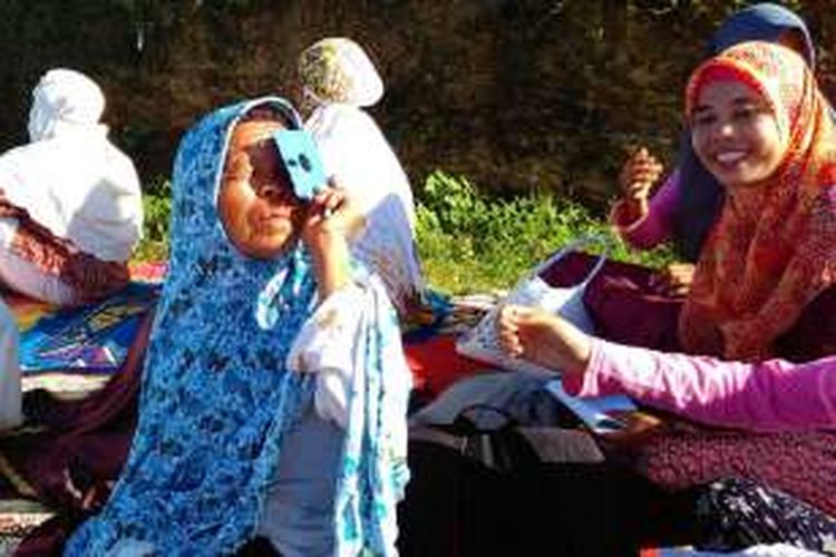 Warga Lombok, Nusa Tenggara Barat melihat gerhana matahari sebagian dengan menggunakan disket bekas
