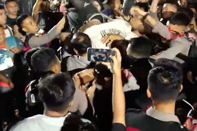 Petugas kepolisian mengamankan seorang penonton mabuk dalam konser dangdut peluncuran Pilbup Probolinggo di stadion Gelora Merdeka, Sabtu (29/6/2024). 