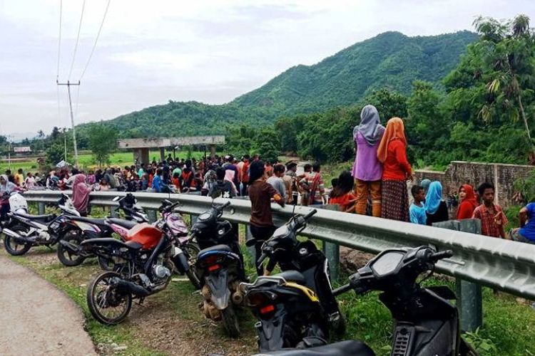Warga memadati jembatan di bendungan Desa Soki, Kecamatan Belo, Kabupaten Bima, saat tim gabungan melakukan pencarian korban hilang terseret banjir, Minggu (14/01/2018) 