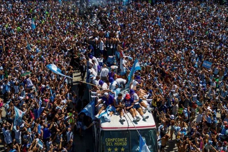 Pemain timnas Argentina menyapa para fans yang turun ke jalanan Buenos Aires dari atas bus terbuka untuk merayakan keberhasilan meraih gelar juara Piala Dunia 2022, Selasa (20/12/2022).