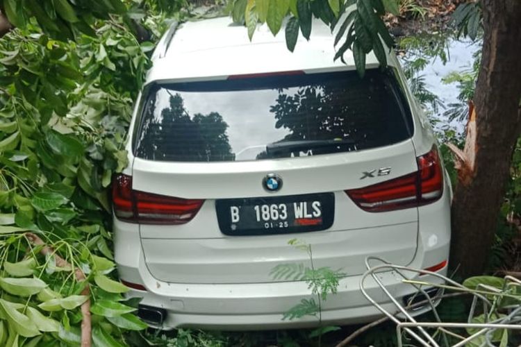 Sebuah mobil BMW bernopol B 1863 WLS terperosok ke parit di sekitar Jalan Outer Ringroad, Kembangan, Jakarta Barat, Jumat (12/11/2021). 