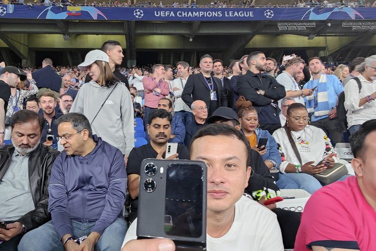 Nicholas Saputra dengan Oppo Find N2 Flip di stadion Ataturk, Turki saat final Liga Champions 2023 berlangsung, Minggu (11/6/2023).