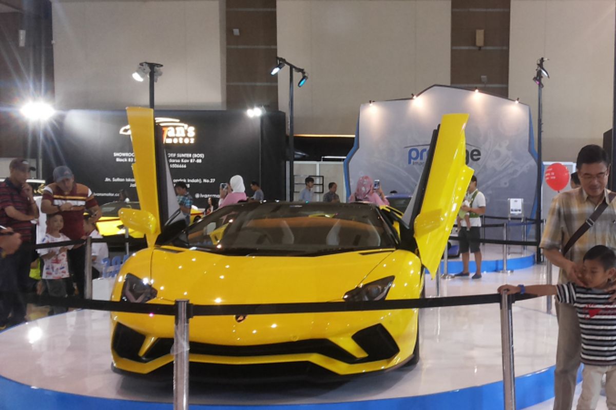 Pengunjung IIMS sedang berpose di depan salah satu Lamborghini yang dipajang di stan Prestige pada hari ketiga penyelenggaraan ajang Indonesia International Motor Show (IIMS) 2018 di JIExpo Kemayoran, Jakarta, Sabtu (21/4/2018).