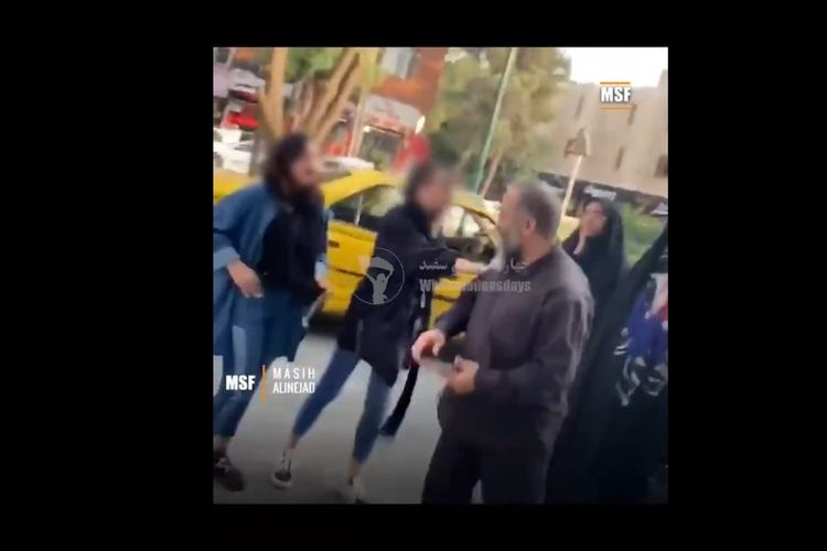 Tangkapan layar dari video yang menunjukkan seorang pria meludahi gadis remaja yang berjalan tanpa memakai jilbab di Iran.