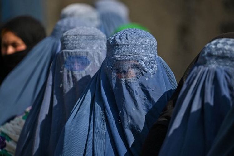 Wanita berpakaian burqa mengantre saat distribusi makanan Program Pangan Dunia di pinggiran Kabul pada 6 November 2021. 