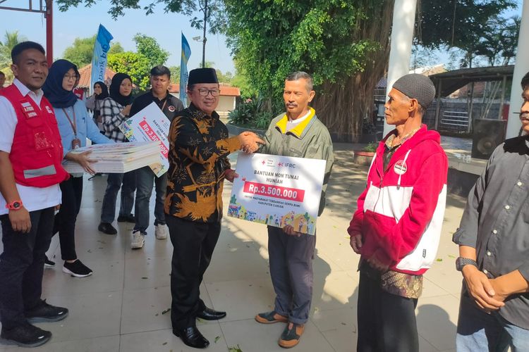 Bupati Cianjur Herman Suherman menyerahkan bantuan nontunai (BNT) kepada warga desa terdampak gempa Cianjur, di Pendopo Pancaniti, Kabupaten Cianjur, Jumat (26/5/2023).