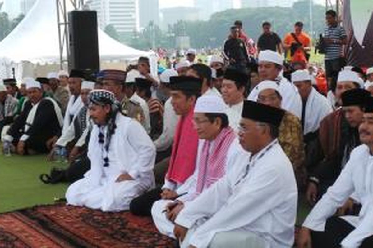 Gubernur DKI Jakqrta Joko Widodo (tengah, menggunakan baju koko putih dengan sarung merah jambu yang dikalungkan di leher) mengikuti istighosah dalam rangka haul ke 43 tahun Perguruan Tinggi Ilmu Quran di Monas, Jakarta, Minggu (9/3/2014).