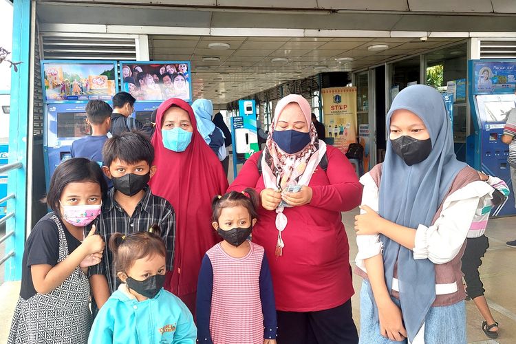 Muhinah (60) dan anaknya, serta 5 cucunya, terkendala saat akan berangkat naik Transjakarta dari Terminal Kalideres, Rabu (5/10/2022). Rombongannya terpaksa membeli 5 kartu tambahan lantaran aturan baru. Padahal, Muhinah mengaku biasanya satu kartu bisa digunakan bersama-sama selagi saldonya cukup.