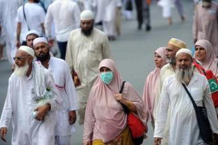 Umat Islam mengenakan masker ketika menuju Masjidil Haram, Kota Mekkah, Arab Saudi, 8 Oktober 2013. Lebih dari dua juta muslim tiba di kota suci ini untuk ibadah haji tahunan.
