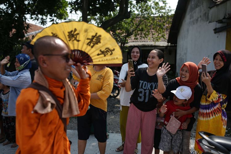 Antusias warga menyambut biksu yang melintas menjalani ritual thudong saat perjalanan dari Kota Tegal ke Pemalang, Jawa Tengah, Rabu (24/5/2023). Sebanyak 32 biksu jalan kaki dari Thailand menuju Candi Borobudur untuk meyambut Hari Raya Waisak.