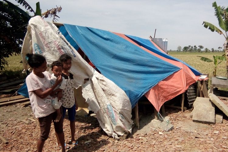 Supriati (30) warga Desa Doreng RT 01 RW 03, Kecamatan Wonosalam, Kabupaten Demak,  Jateng, bersama ketiga anaknya,  hampir satu bulan ini menempati tenda plastik,  Selasa (11/7/2017)