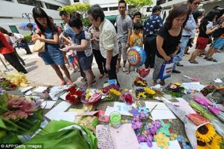 Sejumlah warga Singapura meletakkan karangan bunga dan kartu di luar Singapore General Hospital, Minggu (22/3/2015), saat Lee Kuan Yew masih dinyatakan dalam kondisi kritis. Lee meninggal dalam usia 91 pada Senin dini hari.