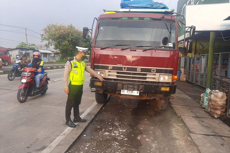 Polisi saat menunjukkan lokasi dan kendaraan yang terlibat dalam kecelakaan lalu lintas di Jalan Raya Desa Moropelang, Kecamatan Babat, Lamongan, Jawa Timur, Selasa (14/3/2023).