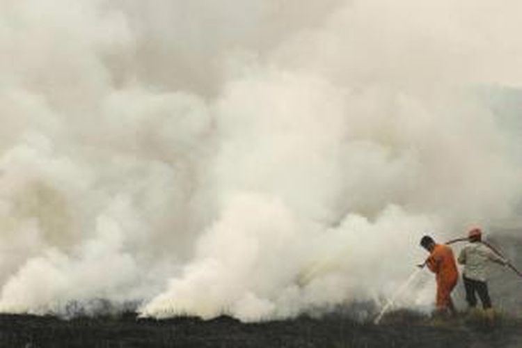 Petugas berupaya memadamkan kebakaran lahan di Ogan Ilir, Sumatera Selatan, 5 September 2015. Kabut asap yang menyelimuti beberapa negara Asia Tenggara disebabkan oleh kebakaran hutan di Indonesia.