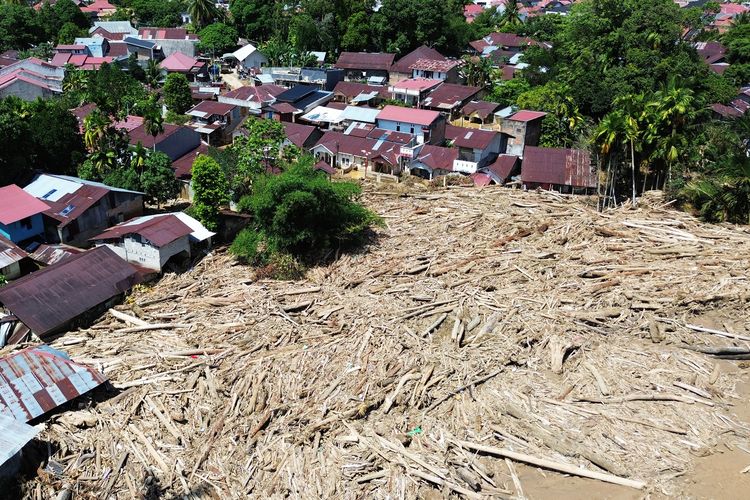 KAYU GELONDONGAN: Foto udara tumpukan gelondongan kayu di permukiman di Tabiang Bandang Gadang, Nanggalo, Padang, Sumatera Barat, Selasa (9/12/2025). Gelondongan kayu yang terbawa banjir bandang sejak dua pekan lalu masih tersangkut di wilayah itu.  