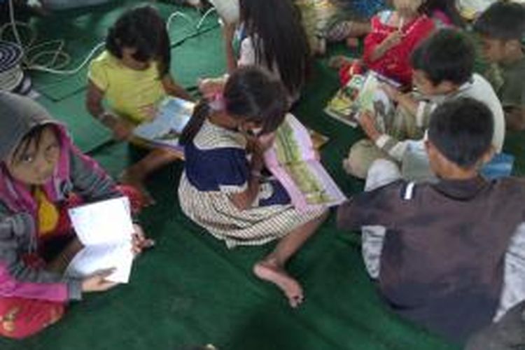 Suasana anak-anak saat asyik membaca buku yang disediakan oleh perpustakaan keliling oleh Korem Bhaladika Jaya Malang.Senin (17/2/2014).