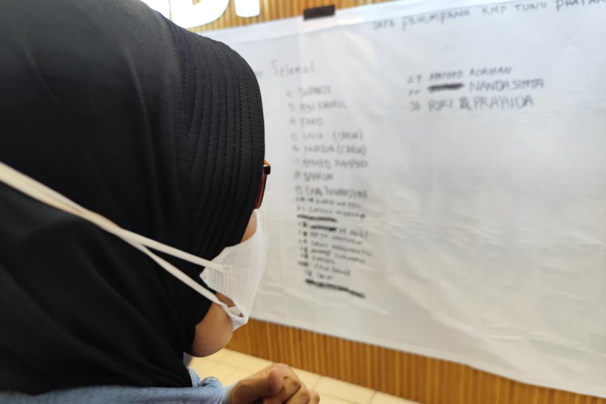 Seorang keluarga tengah melihat daftar penumpang KMP Tunu Pratama Jaya di Posko Pelabuhan Ketapang, Banyuwangi, Jatim, Kamis (3/7/2025). Salah satu korban ada yang bekewarganegaraan Malaysia.