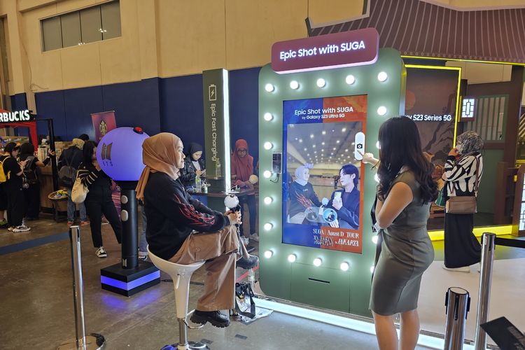 Seorang penonton konser Suga BTS sedang mencoba berpose bersama Suga secara virtual di area booth AR (Augmented Reality) Photo Samsung, menggunakan Galaxy S23 Ultra, di ICE BSD, Tangerang, Jumat (26/5/2023).